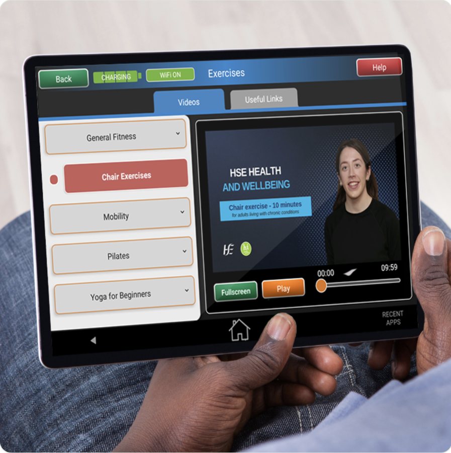 The tablet health hub showing HSE chair exercise videos, with categories for general fitness, mobility, Pilates and yoga